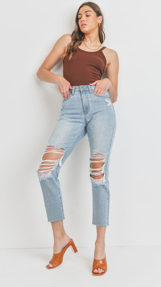 Woman in light-wash distressed straight-leg jeans, a brown tank top, and heeled mules