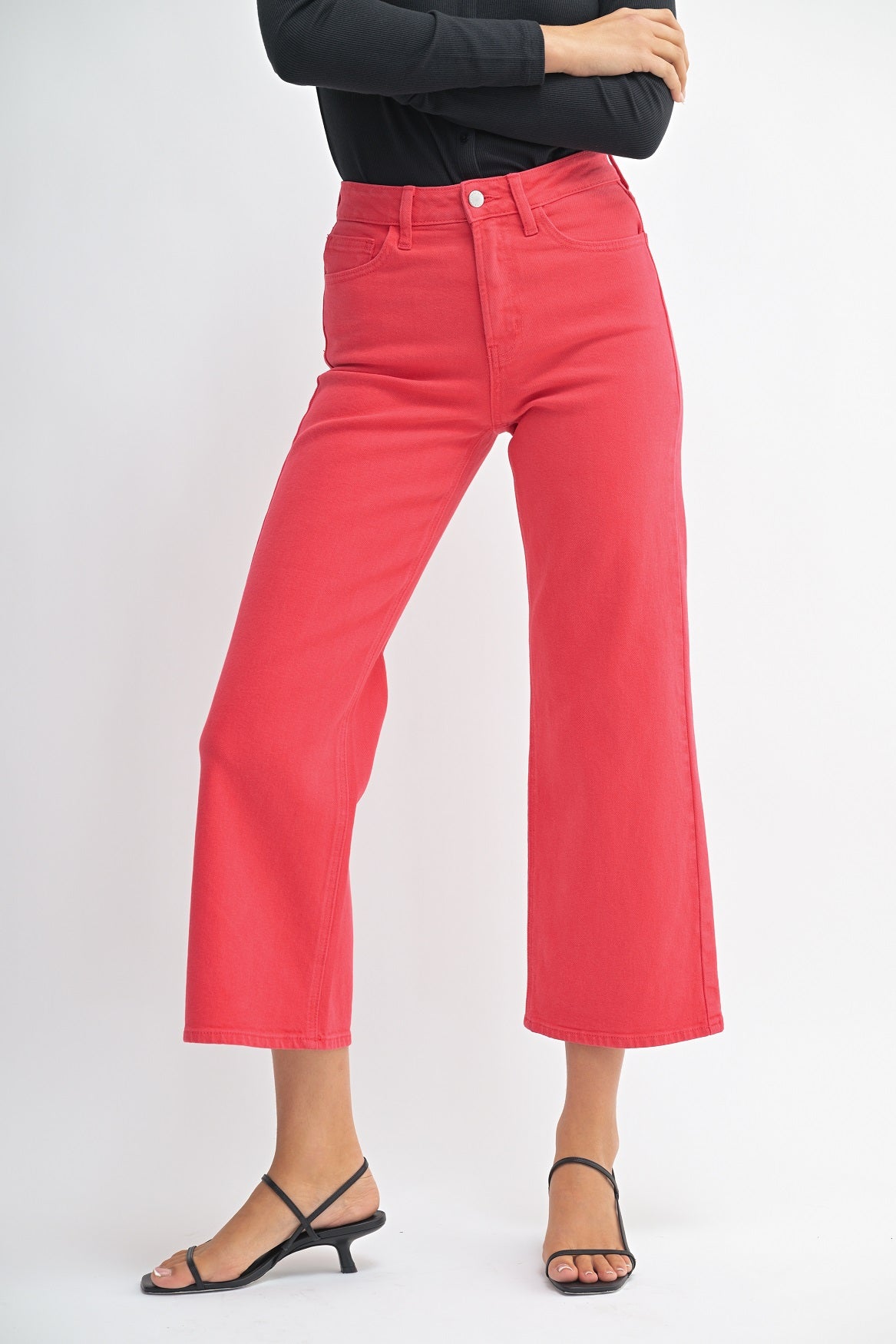 Person wearing red pants and black top on a white background