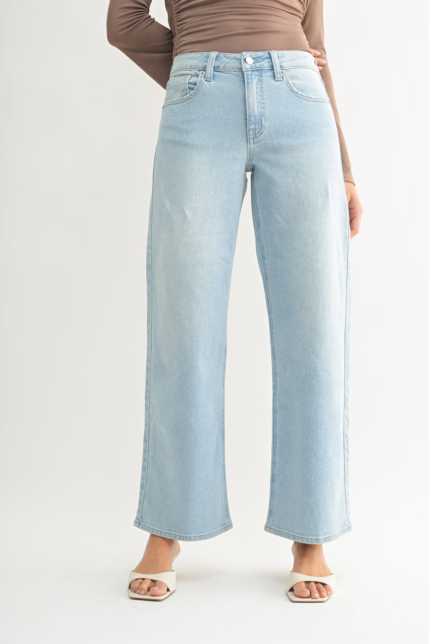 Light blue jeans worn by a person on a white background