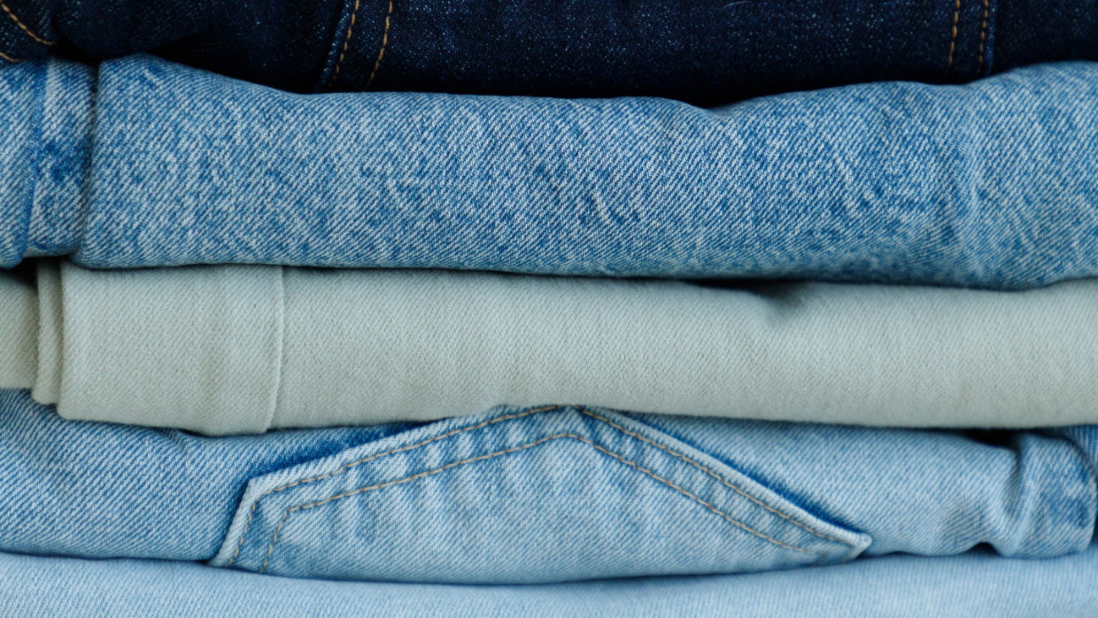 Stack of folded denim jeans in various washes