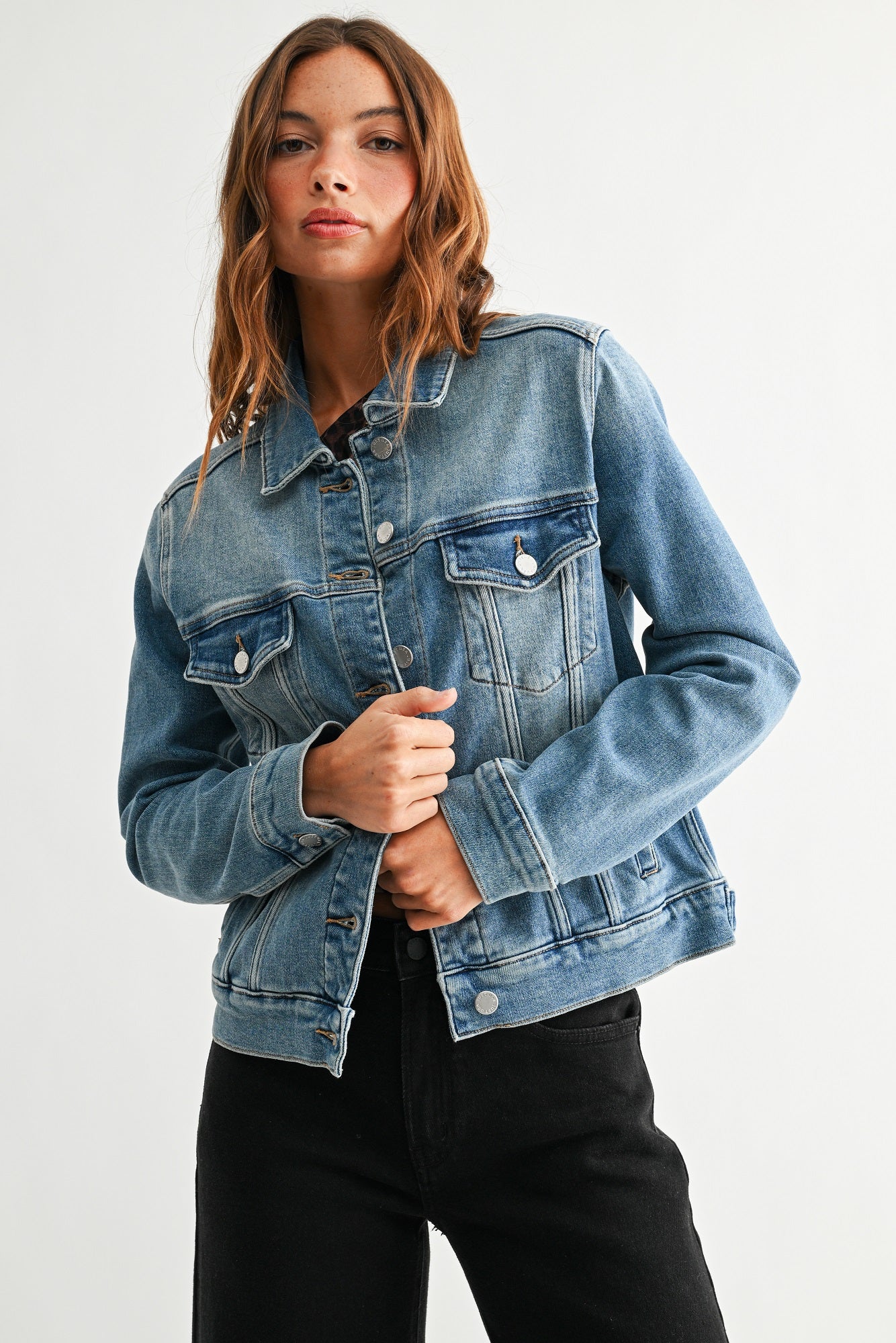 Woman wearing a blue denim jacket on a white background
