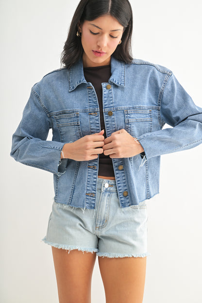 Woman wearing a denim jacket and shorts on a white background