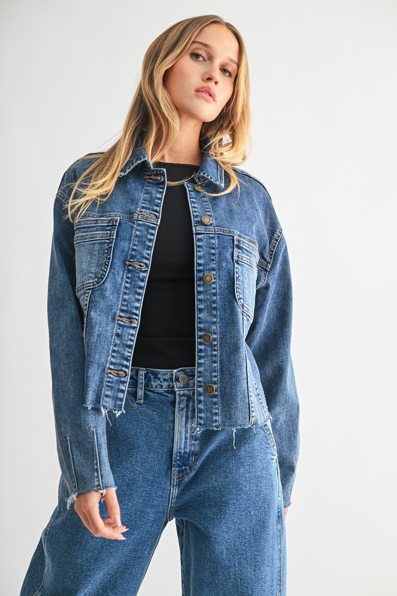 Woman wearing a denim jacket and jeans on a white background