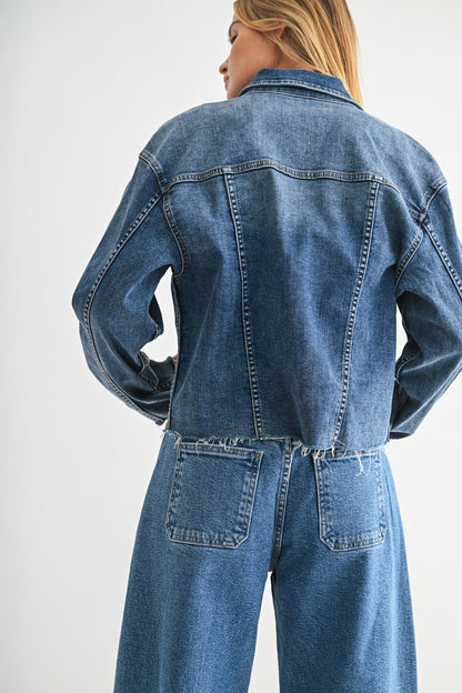 Person wearing a blue denim jacket and jeans on a white background