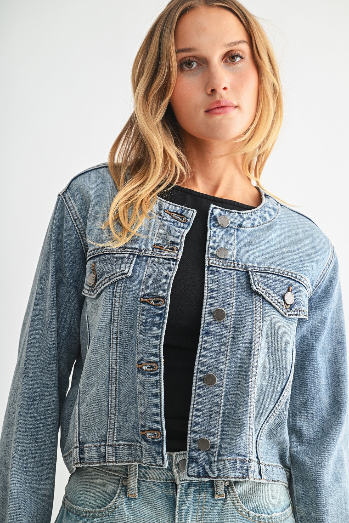 Woman wearing a denim jacket on a plain background