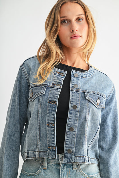 Woman wearing a denim jacket on a plain background