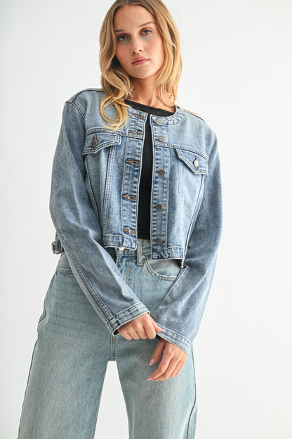 Woman wearing a light blue denim jacket and jeans on a white background