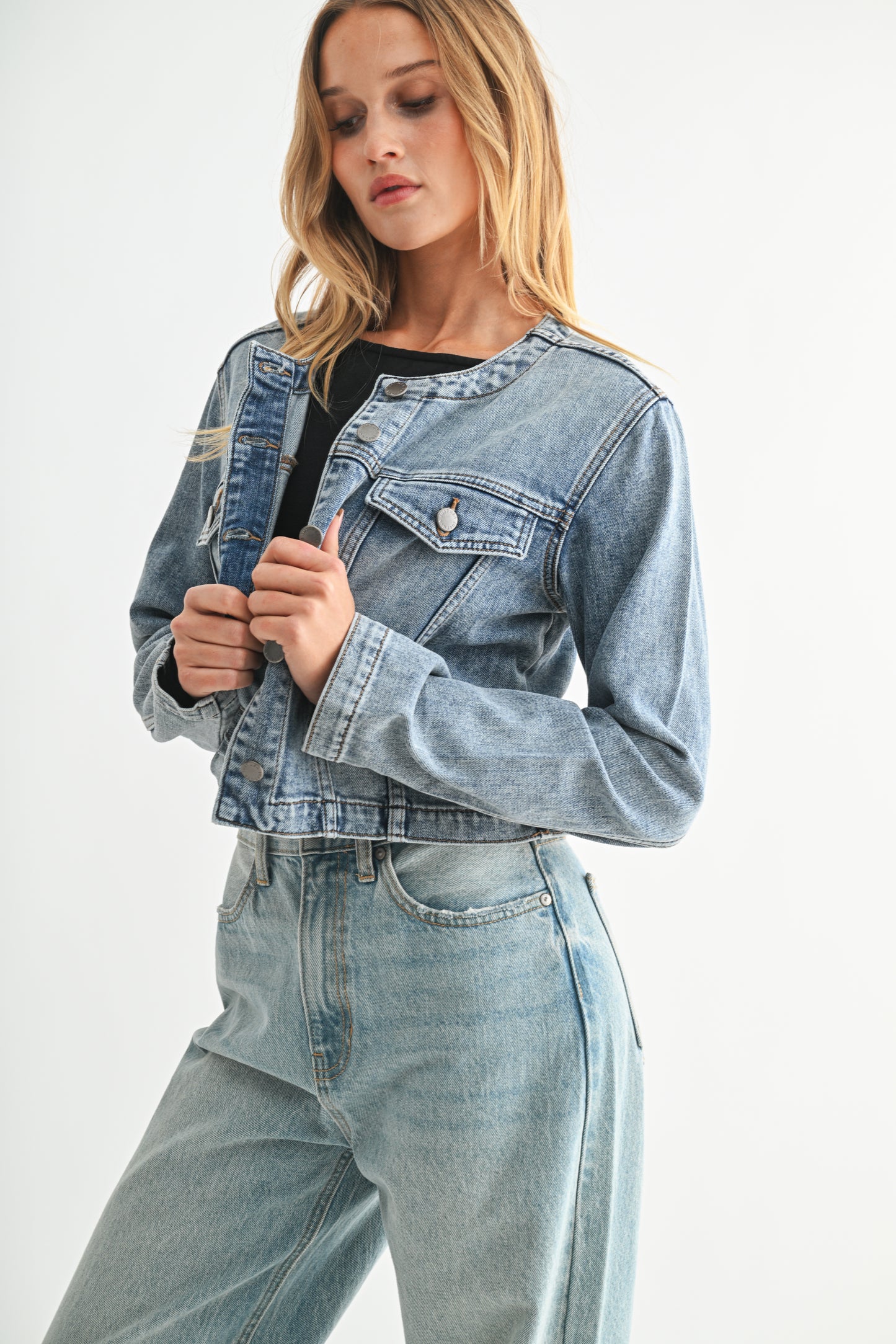 Woman wearing a denim jacket and jeans on a white background