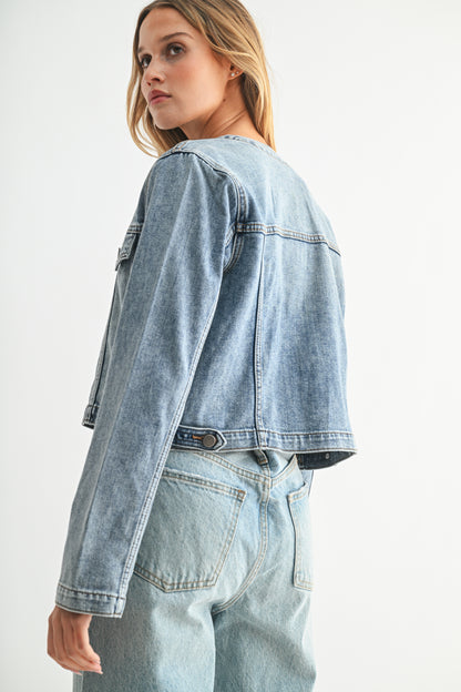 Woman wearing a light blue denim jacket and jeans on a white background