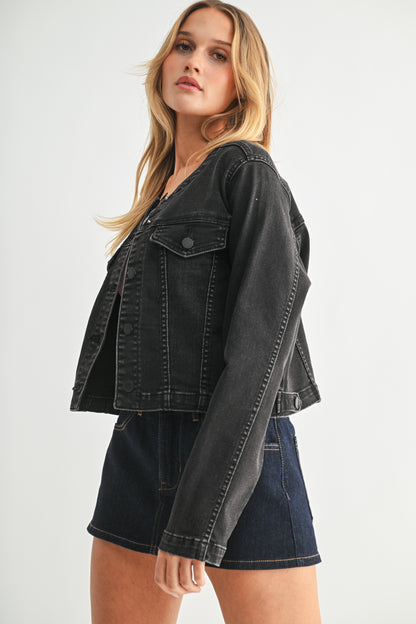 Woman wearing a black denim jacket and skirt on a white background