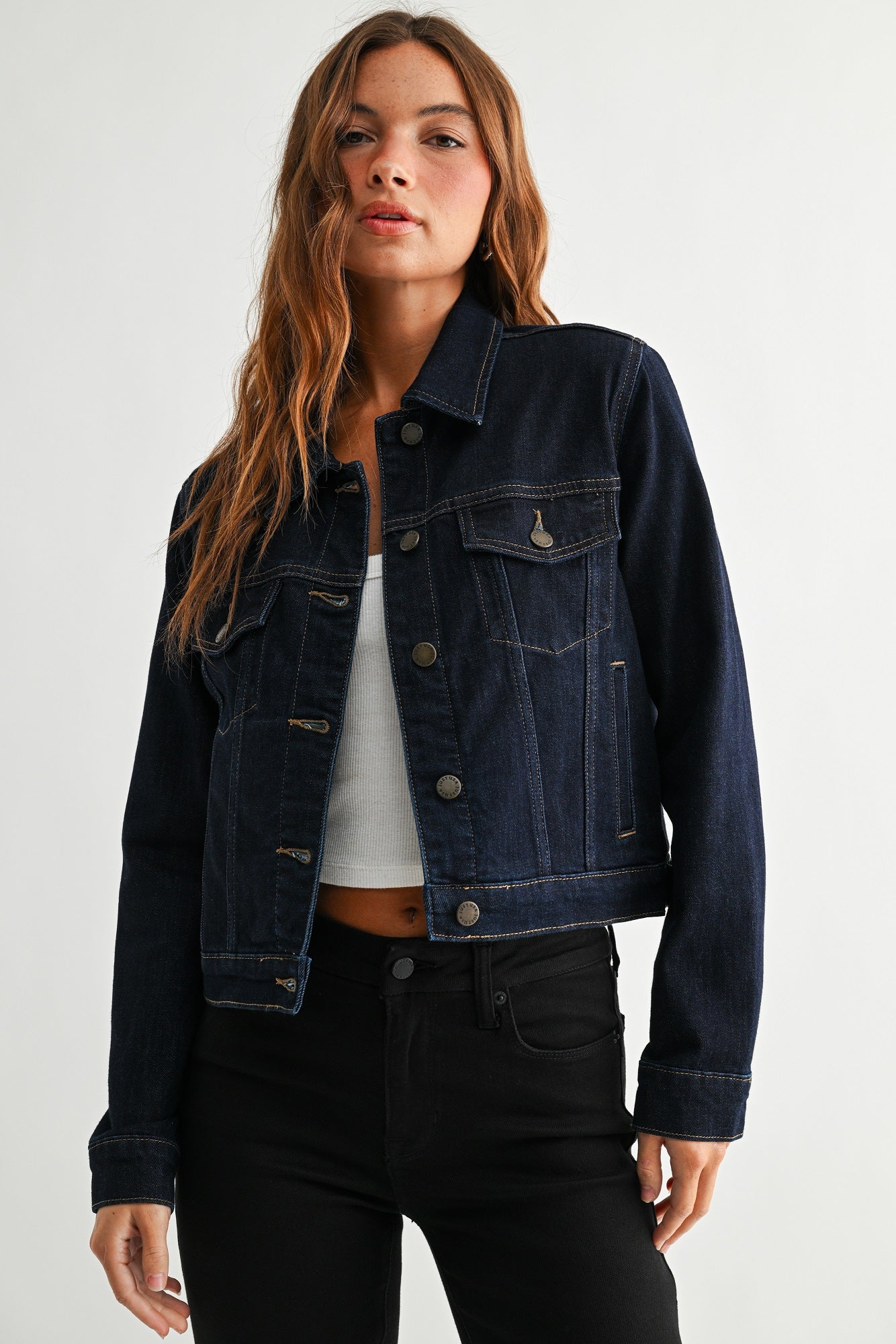 Woman wearing a dark denim jacket on a white background