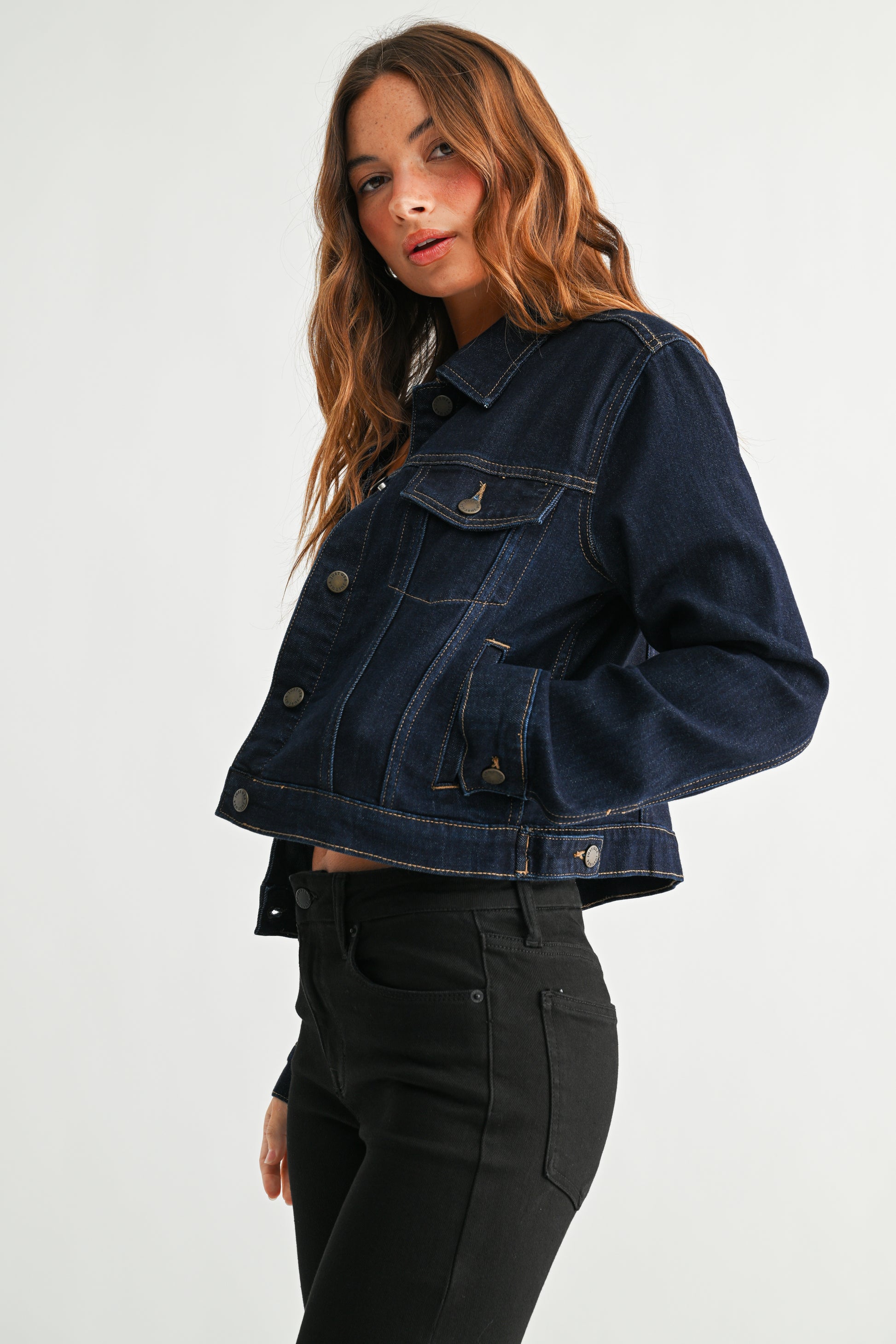 Woman wearing a dark blue denim jacket on a white background
