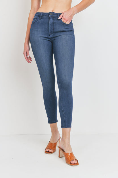 Person wearing blue jeans and brown sandals on a white background