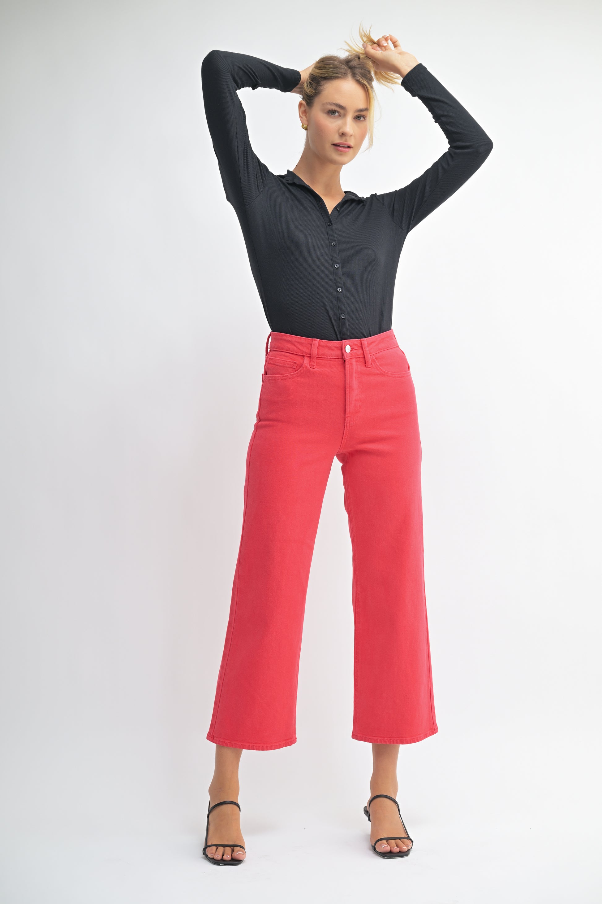 Woman wearing a black shirt and red pants on a white background
