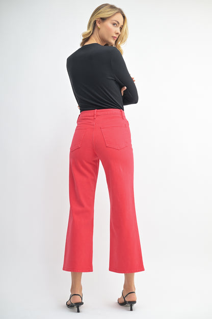 Woman wearing a black top and red pants on a white background