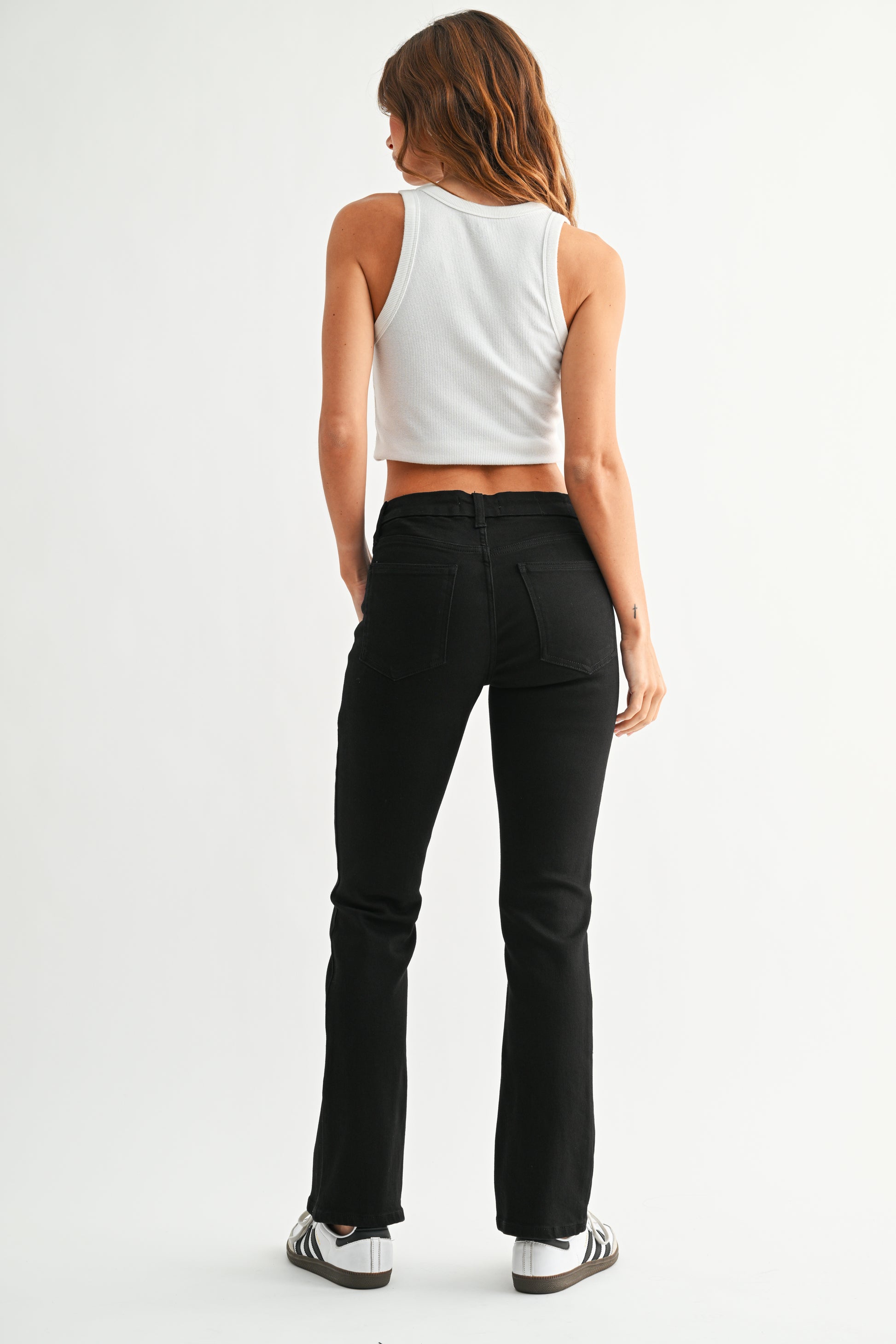 Person wearing black pants and a white top on a white background