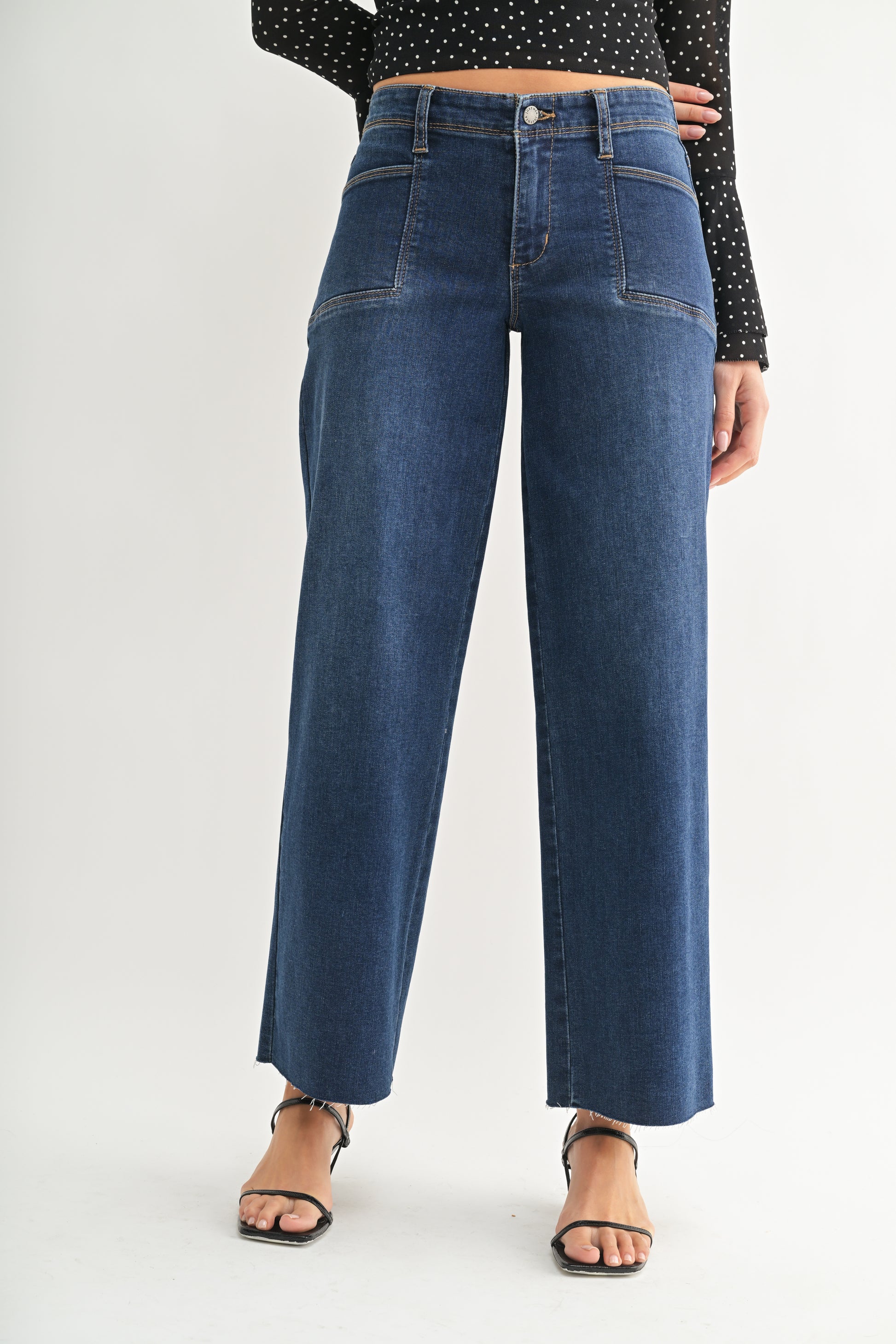 Person wearing high-waisted blue jeans on a white background