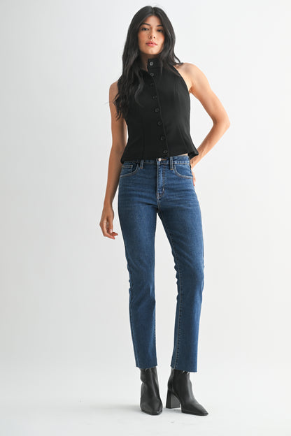 Woman wearing a black sleeveless top and blue jeans on a white background