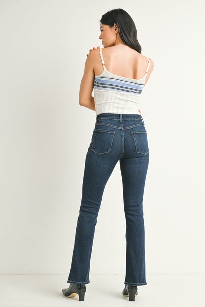 Woman wearing blue jeans and a striped top on a white background