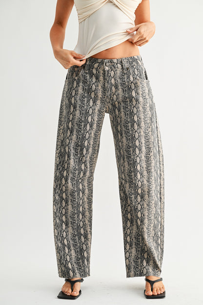 Person wearing snake print pants on a plain background