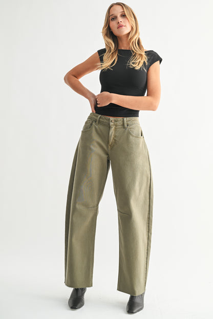 Woman wearing a black top and green pants on a white background