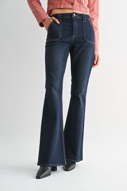 Woman wearing a pink denim jacket and dark blue jeans on a white background