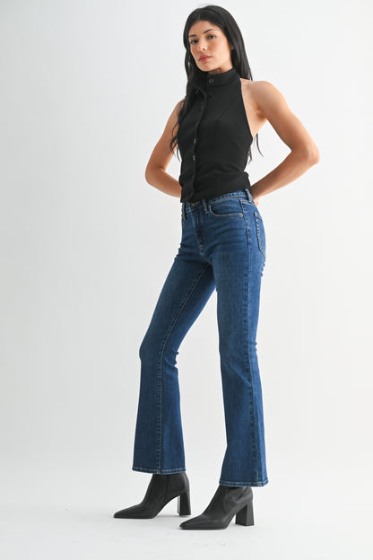 Woman wearing blue jeans and a black top on a white background