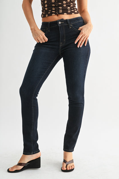 Person wearing dark blue jeans on a white background