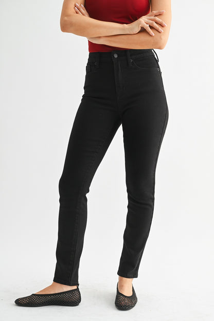 Person wearing black jeans on a white background