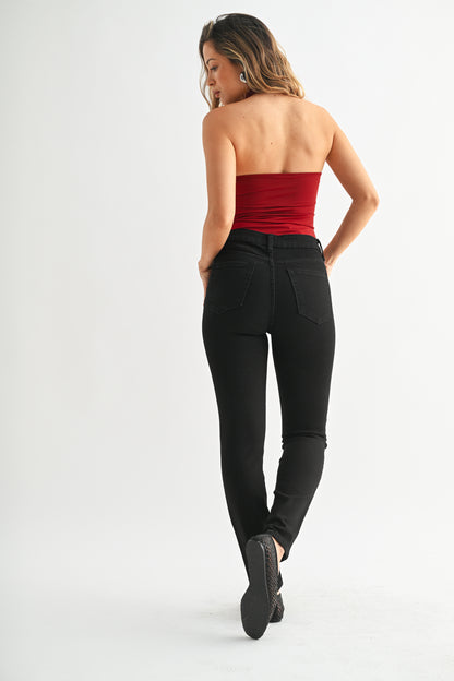 Woman wearing a strapless red top and black pants on a white background