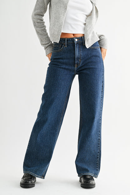 Person wearing blue jeans with a plain background