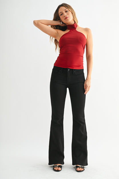 Woman wearing a red top and black pants on a white background