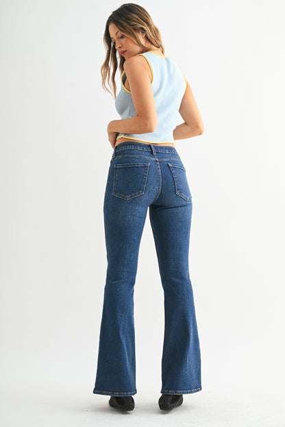 Woman wearing blue flared jeans on a white background