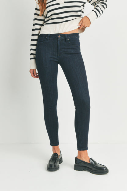 Person wearing dark blue jeans and a striped sweater on a white background