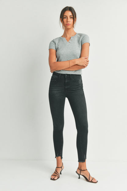 Woman wearing a gray t-shirt and black jeans on a white background